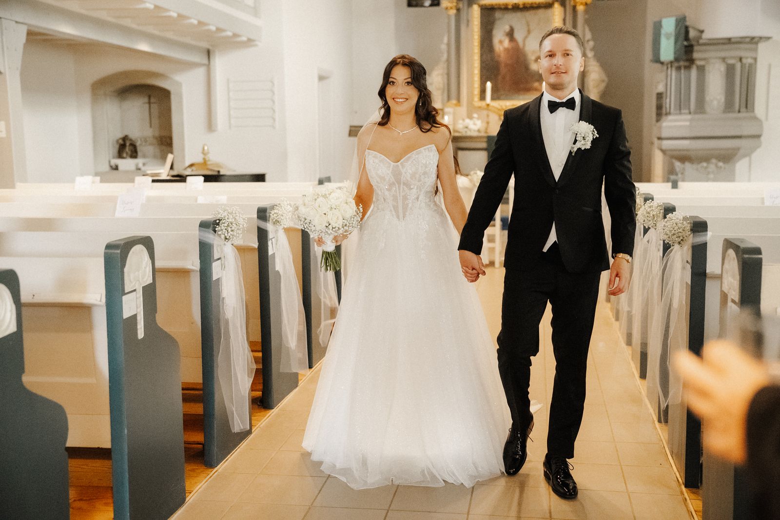 Julia und Sergej gehen nach der Trauung durch die Kirche